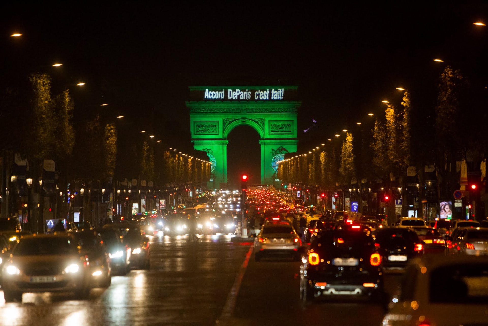 De Arc de Triomphe is groen verlicht met de tekst ‘Accord De Paris c’est fait!’, 2016. (Beeld: Jean-Baptiste Gurliat)