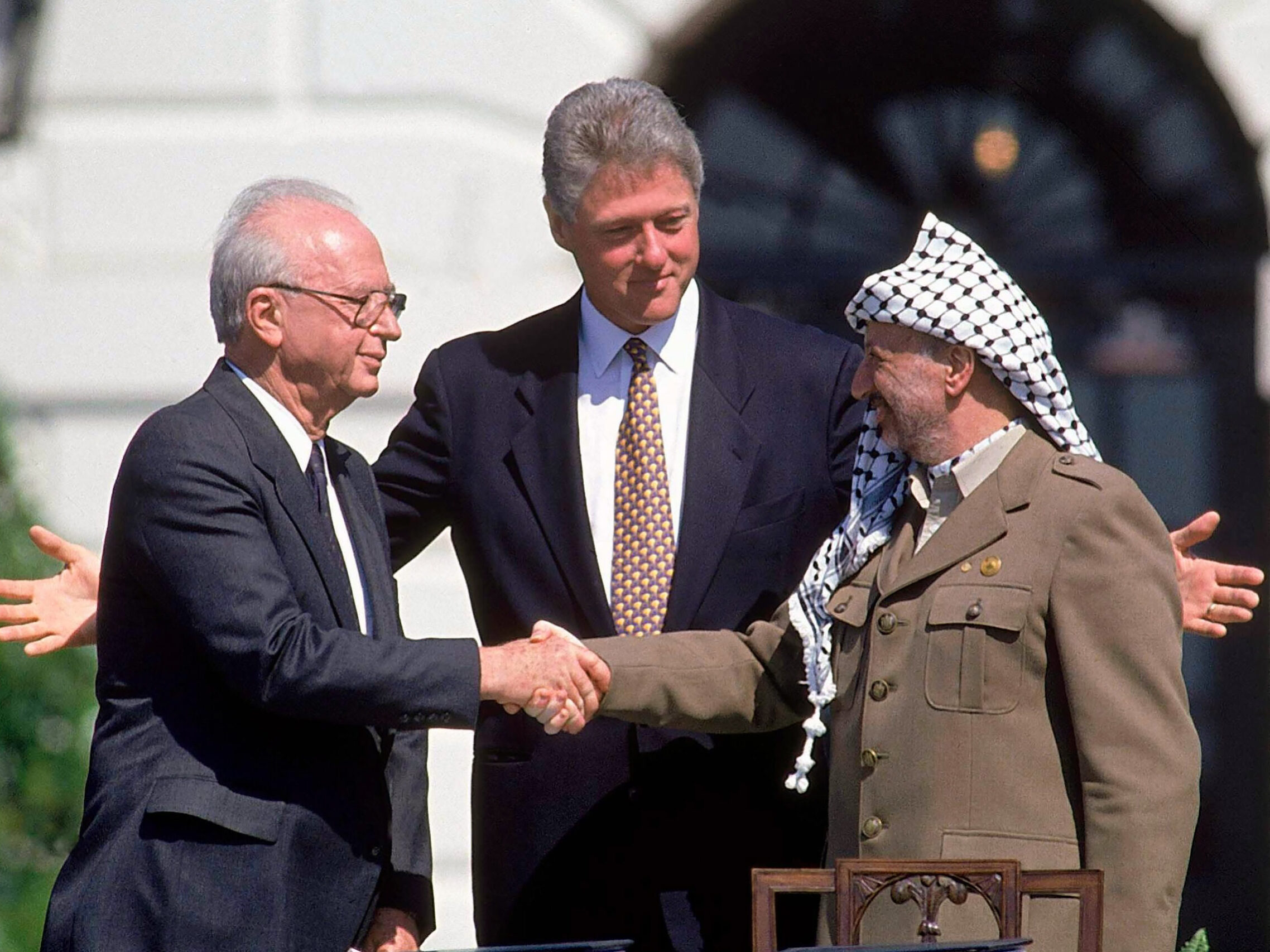 De Israëlische premier Rabin (links) en de PLO-leider Arafat (rechts) sluiten bij de Amerikaanse president Clinton een eerste vredesakkoord, 1993.