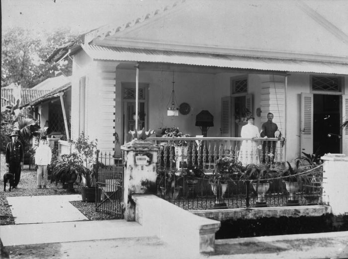 De familie Keyzer (rechts) op hun veranda van hun villa in Makassar met hun bedienden (links), circa 1918. (Beeld: Collectie Tropenmuseum)