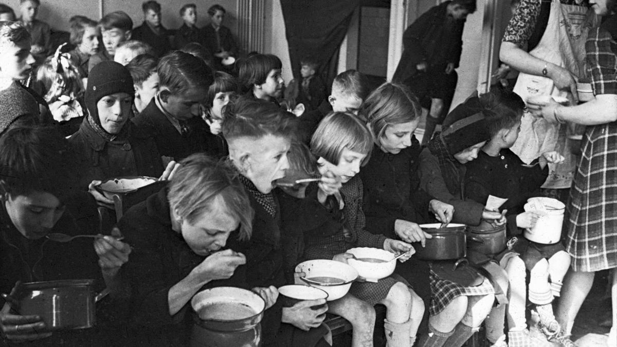 Kinderen in Den Haag krijgen een halve liter ‘bijvoeding’ tijdens de Hongerwinter, 1944-1945. (Beeld: Nederlands Fotomuseum)