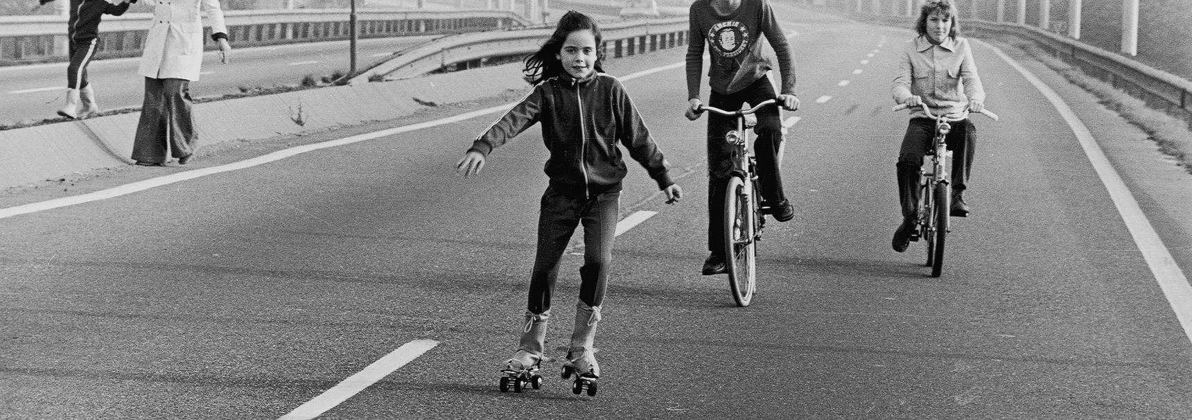 Kinderen rolschaatsen en fietsen op de snelweg tijdens een autoloze zondag, 1973. (Beeld: Benelux Press)