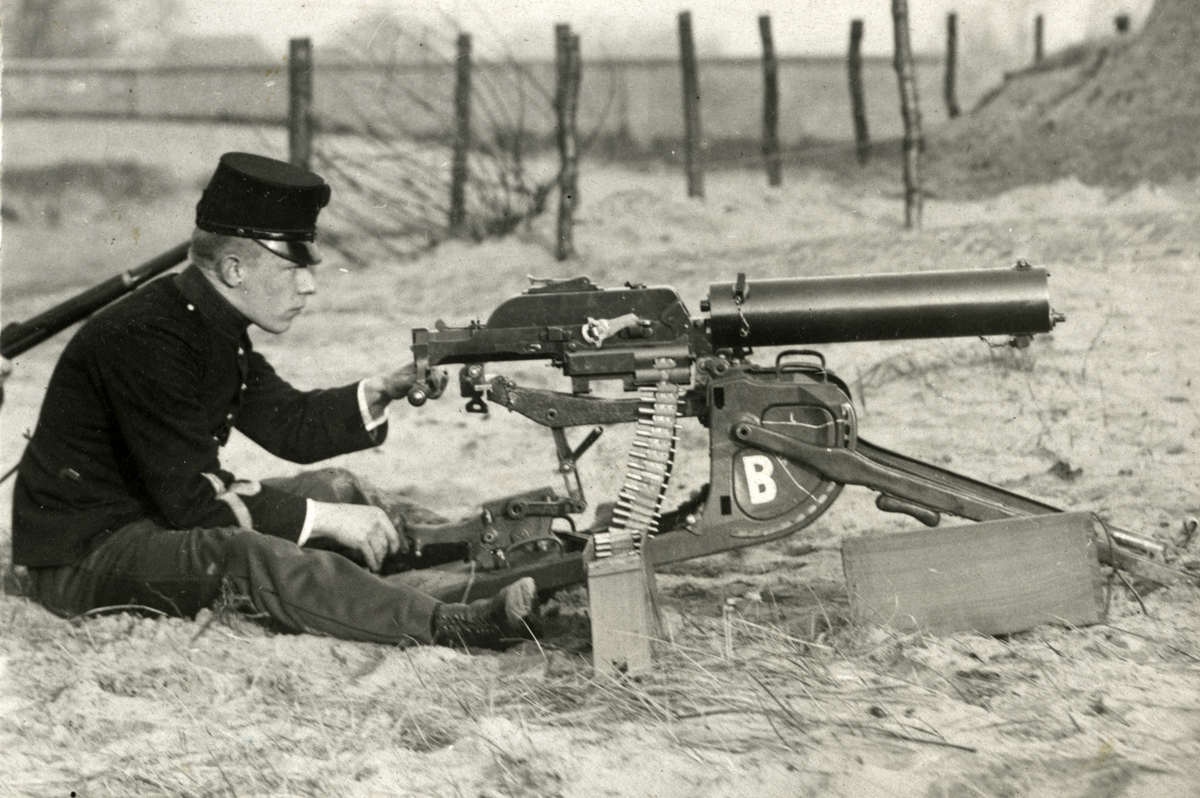 Nederlandse kustwacht, soldaat zit op de grond bij een mitrailleur, 1914. (Beeld: Spaarnestad Photo)