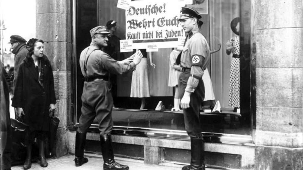 Twee nazi's beplakken een Joodse winkel met de oproep hier niets meer te kopen, 1933. (Beeld: Bundesarchiv)
